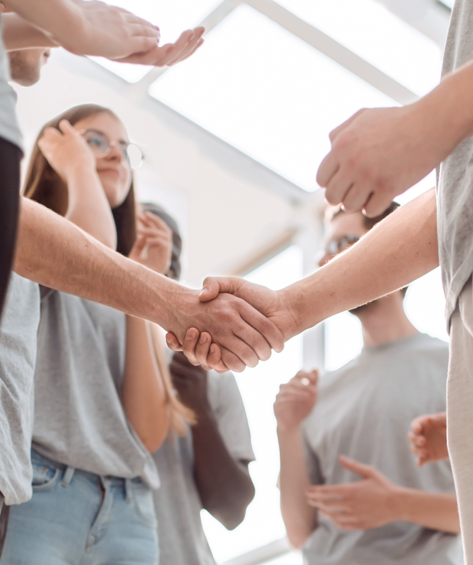 close-up. handshake of young people on the background of the applauding team